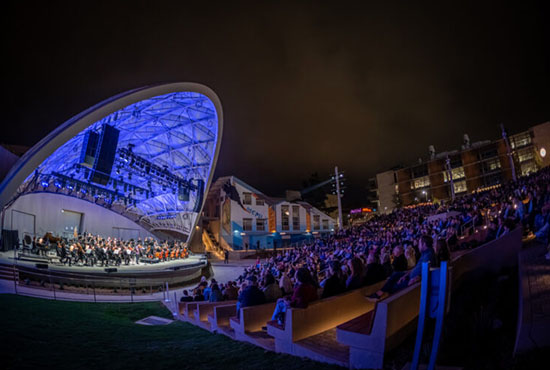 UC San Diego's Epstein Family Amphitheater -- stage lit up at night with a full crowd in the stands